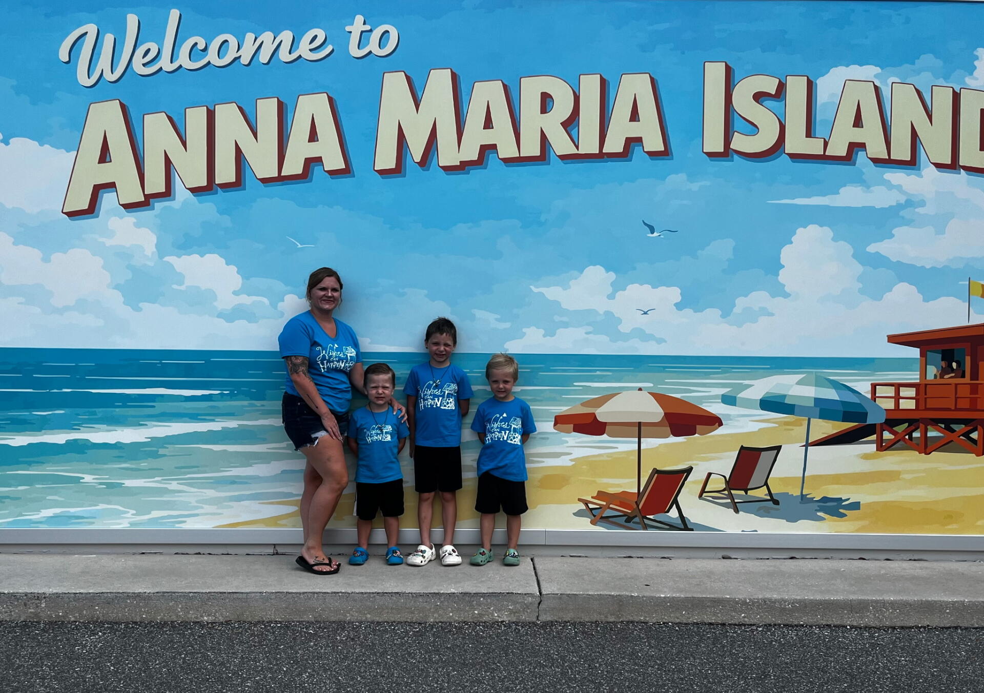 Family in Front of Welcome to Anna Maria Island