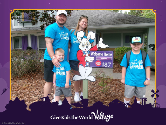 Miles Barnes Family in front of GKTW Villa Sign